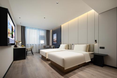 寧海的住宿－宁波宁海亚朵酒店，酒店客房设有两张床和电视。
