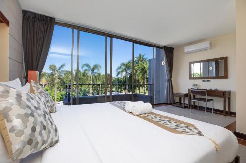 a bedroom with a large white bed and a balcony at Pool Access Villa Argent 8, 3-Bedroom near Mission Hills Golf in Thalang