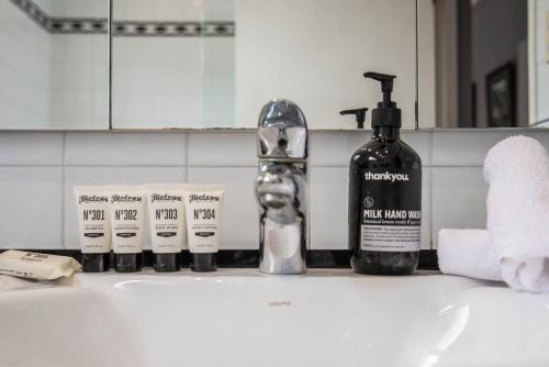 a bathroom sink with a bottle of soap and toothpaste at Great Gatsby Style in the Heart of Double Bay in Sydney