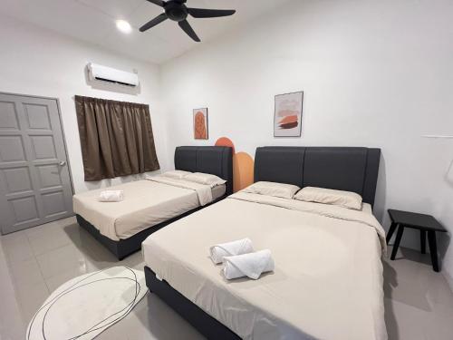 a bedroom with two beds and a ceiling fan at FunkyVila4 14PAX 4BR Near188Tower, ArtStreet, HTTA in Kuantan