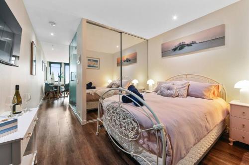 um quarto com uma cama e um espelho grande em Sails by the Bay - Ocean Views - Wi-Fi - Netflix em Frankston