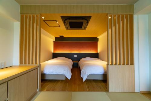 um quarto com duas camas num quarto em Ryokan Toyotomi em Asakura