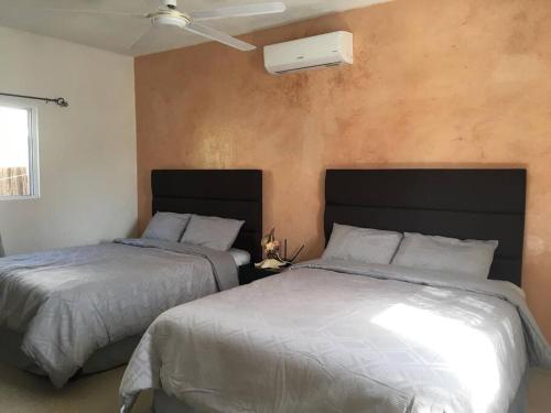 1 dormitorio con 2 camas y pared en Chuburná suites Depa Jr, en Chuburná