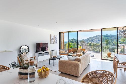 un salon avec un canapé, une table et des chaises dans l'établissement Magnifique Appartement Plage Cavalière Terrasse 3 Chambres Garage, au Lavandou