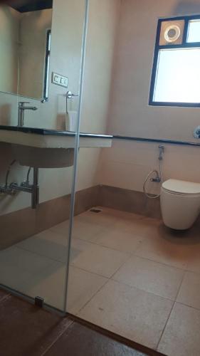 a bathroom with a sink and a toilet at Le MIAMI RESORT in Pondicherry