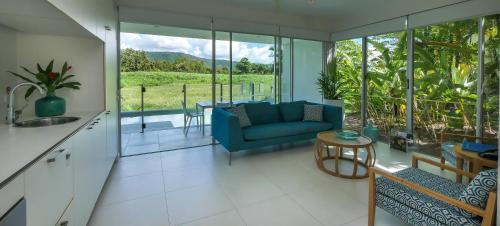 a kitchen and living room with a couch and a table at Pool Resort Port Douglas in Port Douglas