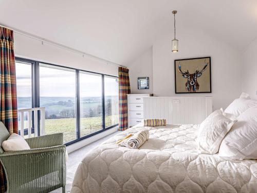 1 dormitorio con cama y ventana grande en 1 Bed in Combe Martin 77349, en Loxhore