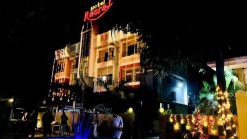 Un edificio di notte con persone che ci stanno davanti di Hotel Rasraj , Dhule a Dhule