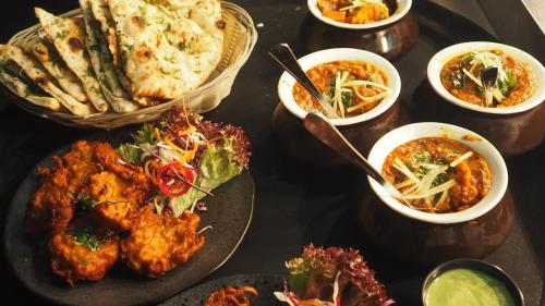 een tafel met borden en schalen van voedsel bij Hotel Serenity in Kathmandu