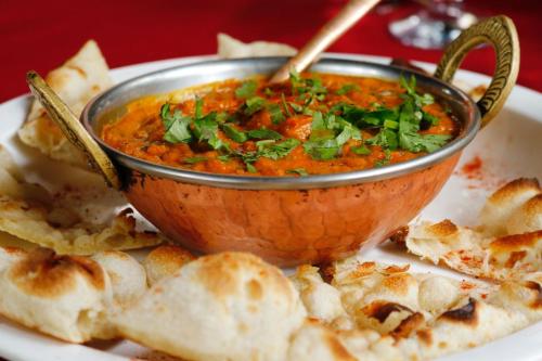 a bowl of soup on a plate with bread at Hotel Serenity in Kathmandu