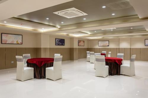 a conference room with two tables and white chairs at FabHotel Prime Oasis Orange in Bhopal