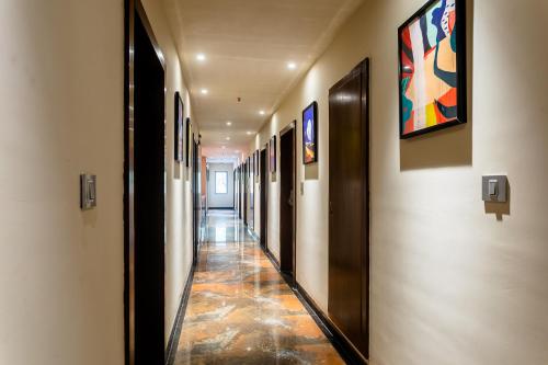 a hallway of a building with paintings on the walls at FabHotel Prime Oasis Orange in Bhopal