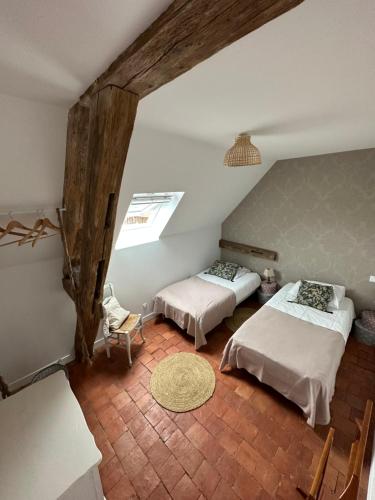 une chambre avec deux lits dans une pièce dans l'établissement La tinoche, à Sauvigny-le-Bois