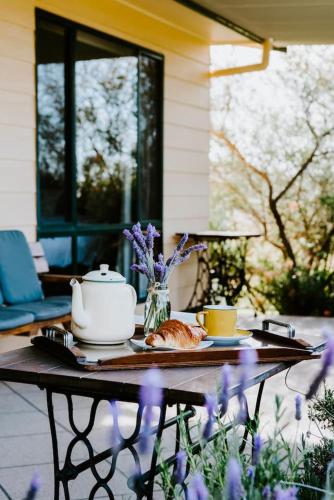 a table with a tea pot and a cat on it at Ithaca Farm Cottage - Country View Seclusion in Mudgee