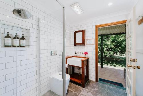 a white bathroom with a sink and a shower at Idyllic Farm Stay Seclusion at Ithaca Cottage in Stony Creek