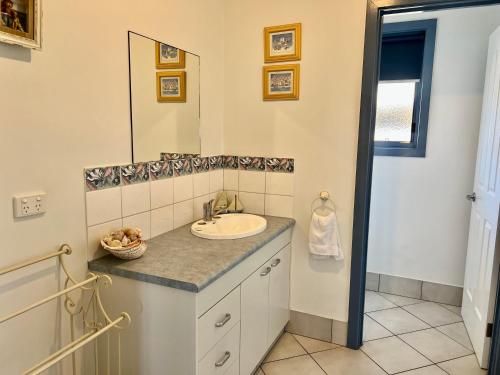 a bathroom with a sink and a mirror at Blue Poles - Pet Friendly in Robe
