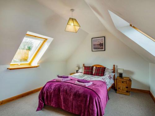 um quarto com uma cama com uma colcha roxa e uma janela em 3 Bed in Huntly 57368 em Insch