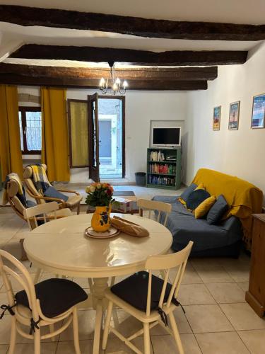 sala de estar con mesa y sofá en Historic French townhouse en Saint-Thibéry