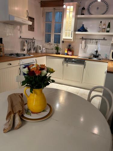 une cuisine avec un vase jaune et des fleurs sur une table dans l'établissement Historic French townhouse, à Saint-Thibéry