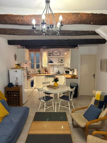 ein Wohnzimmer mit einem Tisch und einer Küche in der Unterkunft Historic French townhouse in Saint-Thibéry