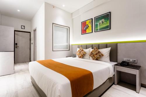 a bedroom with a large bed in a room at FabHotel Prime Oasis Orange in Bhopal