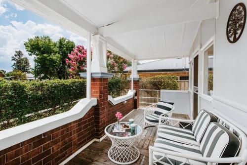 a patio with two chairs and a table on a house at Court House Hideaway - Country Comfort in Town in Mudgee