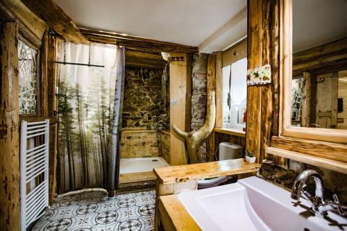 een vuile badkamer met een wastafel en een bad bij Tatra Magic in Malužiná