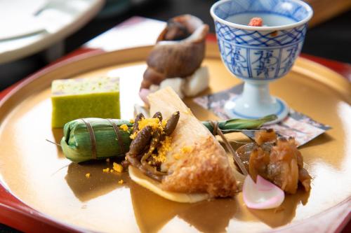 a plate of food on a table with food on it at Ryokan Toyotomi in Asakura