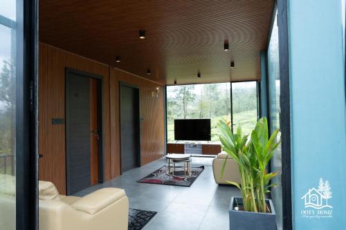 a living room with a couch and a television at OOTYHOMZ LUXURY STAY in Ooty