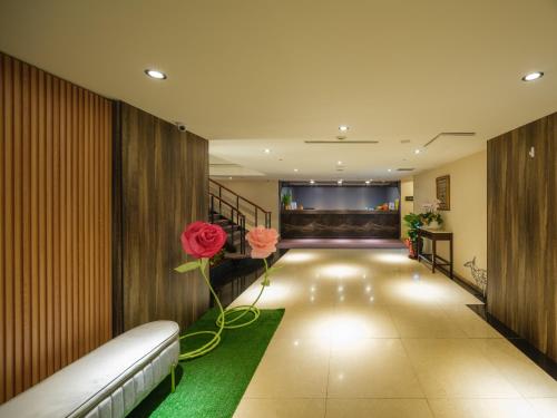 a corridor of a hotel with a flower on the wall at Rich & Free Hotel - Fuzhong 富逸旅趣-板橋府中館 in Taipei