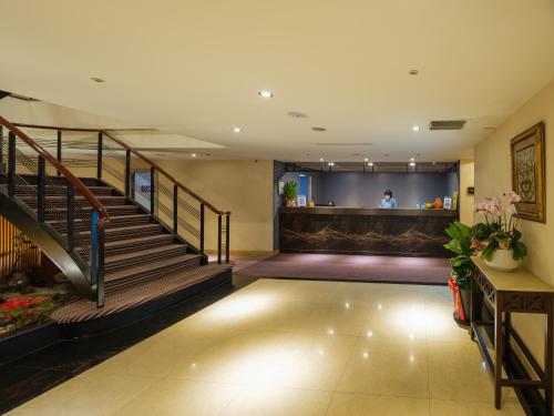 a lobby of a hotel with stairs and a bar at Rich & Free Hotel - Fuzhong 富逸旅趣-板橋府中館 in Taipei