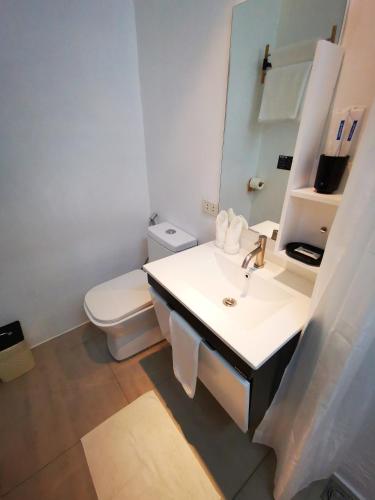 a white bathroom with a sink and a toilet at Urban Boutique Hotel in Boracay