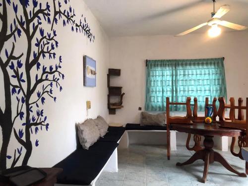 a living room with a tree mural on the wall at El bungaló in Tecolutla