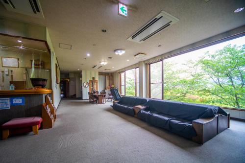 a living room with a blue couch in a building at Ryokan Toyotomi in Asakura