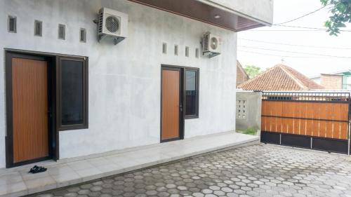 a white house with brown doors and a courtyard at Chersonese Kost in Alastuwo