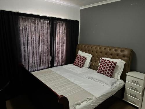 a bed with two pillows on it in a bedroom at Ankazimia House at Reeds View in Roodepoort