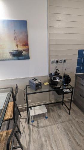 a room with a glass table with a radio on it at Datcha Bourguignonne Beaune in Beaune