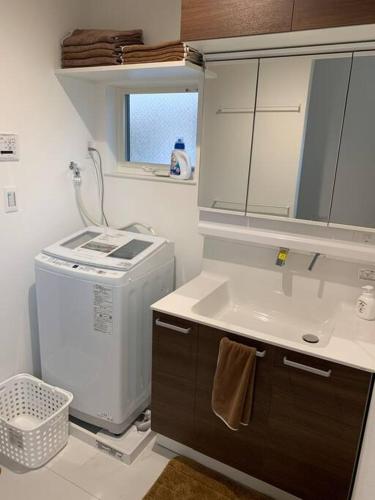 a small kitchen with a sink and a washing machine at 藤沢HOME-1f in Fujisawa