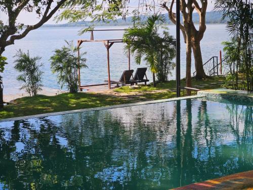 a swimming pool with a view of the water at Las Luciernagas Hotel in Flores