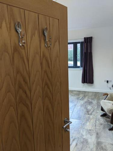 a wooden door in a room with a window at Private garden annexe with kitchenette in Gedney