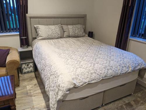 una camera da letto con un grande letto e un piumone bianco di Private garden annexe with kitchenette a Gedney