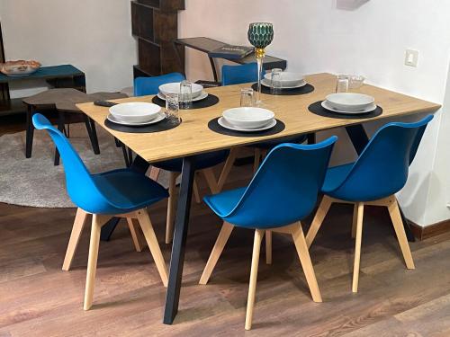 uma mesa de madeira com cadeiras azuis à volta em Chionodoxa Places em Camigliatello Silano