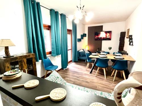uma sala de estar com uma mesa e cadeiras azuis em Chionodoxa Places em Camigliatello Silano