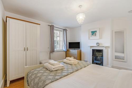 a bedroom with a bed with two towels on it at Westgate Cottage A cosy city centre cottage with private rear garden in Winchester