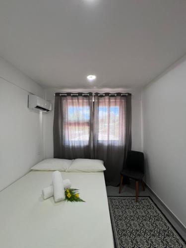 a bedroom with a white bed with a flower on it at OTEMANU LODGE in Bora Bora