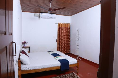 1 dormitorio con 1 cama y ventilador de techo en MarariBeachLaVista1, en Alleppey