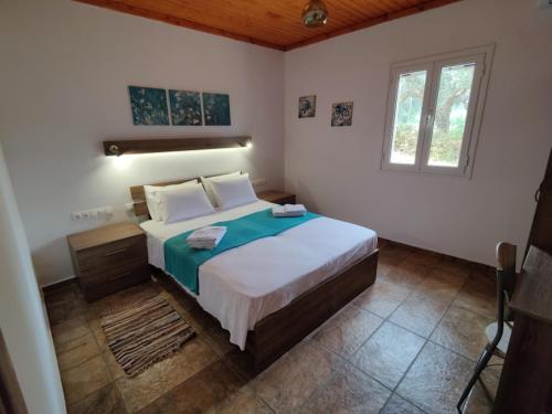 1 dormitorio con cama y ventana en ArokariApartments, en Koroni