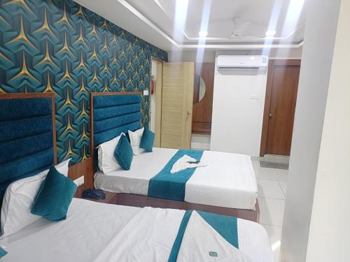 1 dormitorio con 2 camas en azul y blanco en ROYAL PRIME HOTEL, en Vadodara