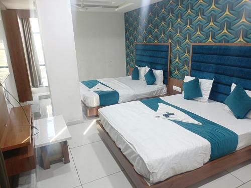 two beds in a room with blue and white at ROYAL PRIME HOTEL in Vadodara