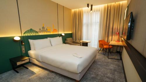 a bedroom with a large white bed in a room at Holiday Inn Tashkent City by IHG in Tashkent
